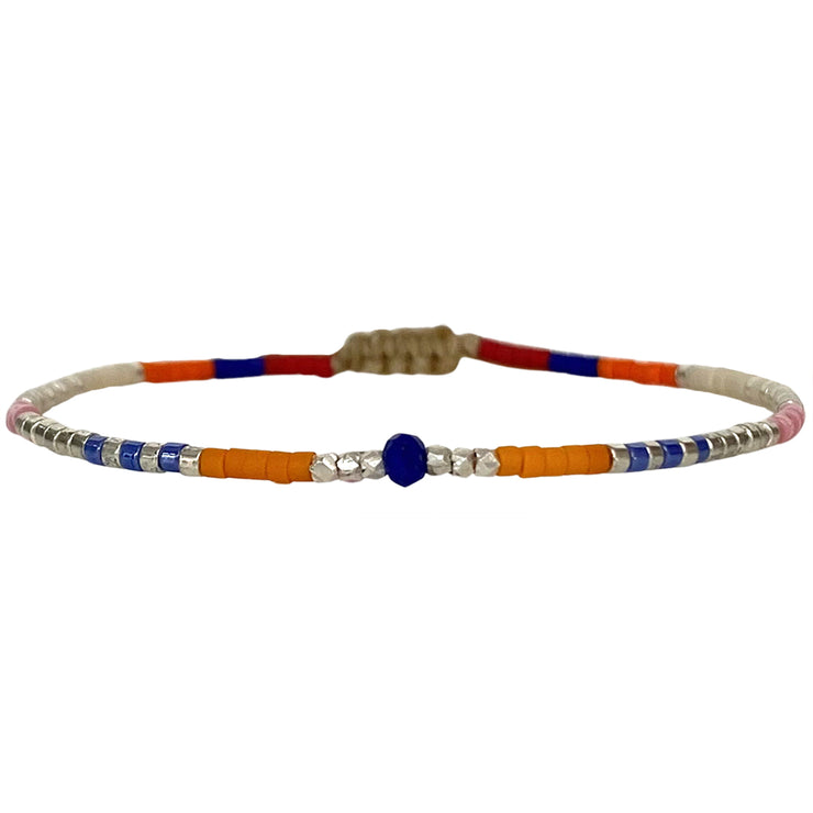  Handwoven in Colombia, this feminine bracelet features a single row of Japanese glass beads in gold and bright tones with a Lapis Lazuli stone of strenght and discipline in the centre.  Wear this stylish bracelet alone or as a part of a bracelet layering combination, with your favourite jeans & t-shirt!  Details:  - Japanese glass beads  - Silver faceted beads  -Lapis lazuli  - Width: 2mm  - Adjustable bracelet 