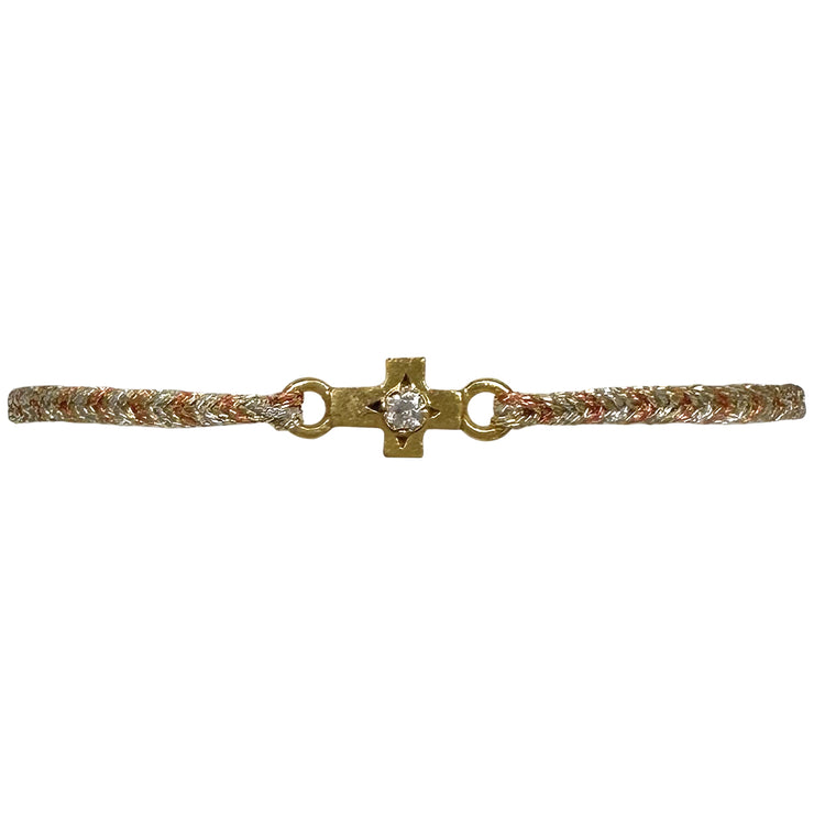 This delicate bracelet is handmade by our team of master artisans using metallic threads and a gold cross charm encrusted with a beautiful zircon stone. It&