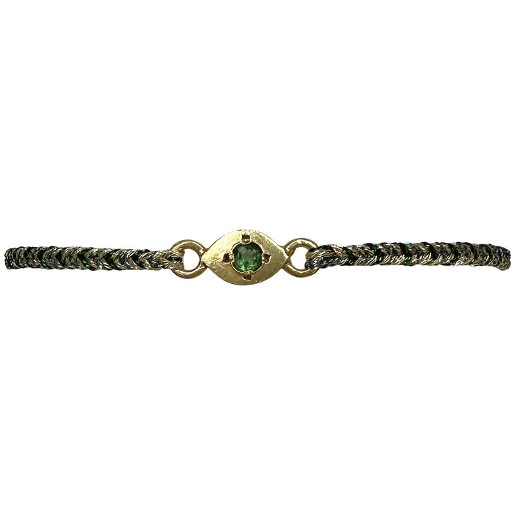 This delicate bracelet is handmade by our team of master artisans using metallic threads and a gold eye charm encrusted with a beautiful green tourmaline stone. It&