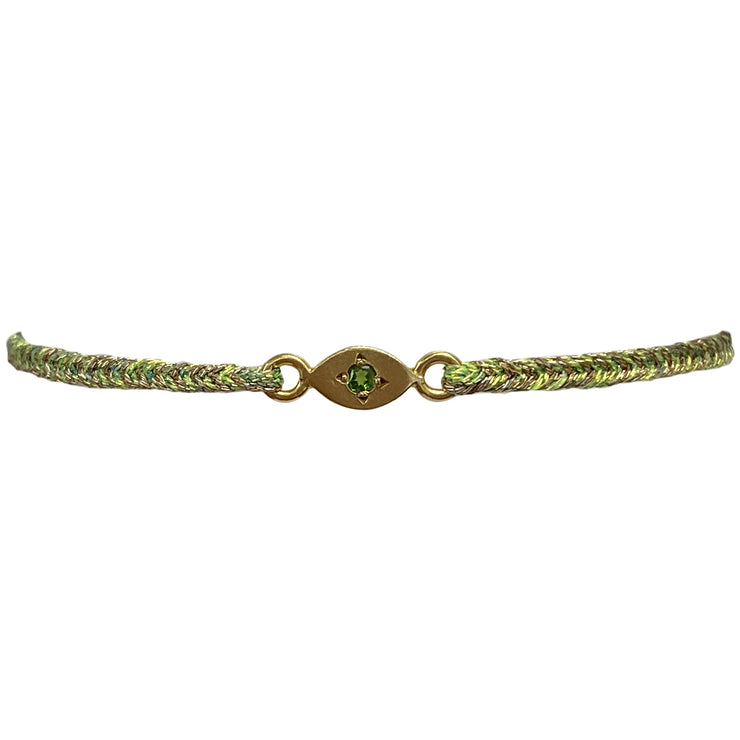 This delicate bracelet is handmade by our team of master artisans using metallic threads and a gold eye charm encrusted with a beautiful green onyx stone. It&