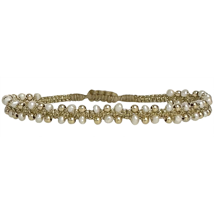 This delicate and beautiful bracelet is handwoven by our team of artisans using freshwater pearls, 14K gold filled beads and metallic threads.   You can wear it with your favourite bracelets all season long.   Details:  -Freshwater pearls  -14k gold filled beads details   -Adjustable bracelet  -Width: 4mm  -Can be worn in the  water