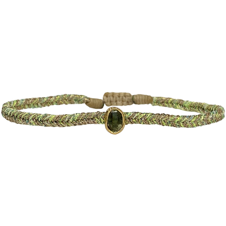 This elegant design is handwoven by our team of master artisans using meatallic threads and a beautiful green tourmaline stone charm.  The beautiful and rare tanzanite stone will bring elegance to any outfit.   Details:  - Handmade bracelet  -Green tourmaline semi-precious stone  -Vermeil setting   -Metallic threads   -Adjustable bracelet   -It comes with a card and a gift box 
