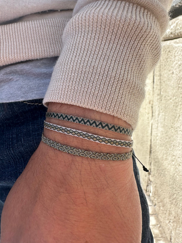 This bracelet features a brown strap with a black strip running down the center, creating a unique and eye-catching contrast.