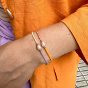 Make a confident statement with this beautiful handmade bracelet. This design is handwoven by our team of artisans using japanese glass beads,14k gold filled beads and a freshwater pearl.  This bracelet is elegant and femenine, making it the perfect accessory for any occasion.  Details  - Japanese glass beads   - 14 k gold filled beads  - Adjustable Bracelet  -Width: 2mm  -Can be worn in the  water