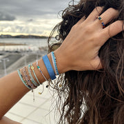 Delicate & feminine, our gypsy bracelet is handwoven using metallic silver threads and intermixed semi-precious stones.   Wear it with your favourite accessories all season long!  Details:  - Intermixed semi-precious stones   - silver faceted beads   -Metallic threads  -Adjustable bracelet   -Can be worn in the water