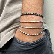 This bracelet has been handwoven in Colombia by our team of master artisans using 925 silver beads and wax threads. This masculine design looks great worn solo or stacked with other pieces.  Details:      925 sterling silver centrpiece     Italian wax threads     Adjustable handwoven bracelet     Width 4mm      Can be worn in the water