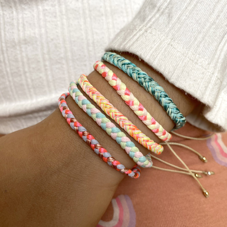 This bracelet is handwoven by our team of master artisans using polyester threads featuring a trenza design in bright tones. This kids&