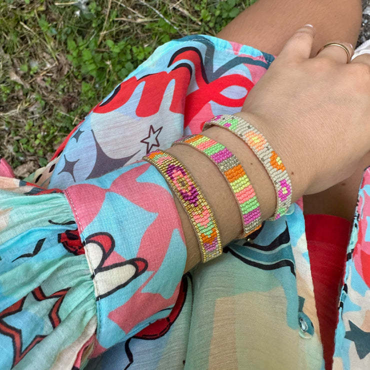 This stunning adjustable bracelet is handwoven using Japanese  glass beads and features flower print patterns in bright tones.  Wear yours stacked or solo to add a mood-boosting pop of color to any neutral look!  Details:      Japanese glass beads     Handwoven adjustable bracelet     Width11mm     Can be worn in the water