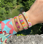This stunning adjustable bracelet is handwoven using Japanese  glass beads and features flower print patterns in bright tones.  Wear yours stacked or solo to add a mood-boosting pop of color to any neutral look!  Details:      Japanese glass beads     Handwoven adjustable bracelet     Width11mm     Can be worn in the water