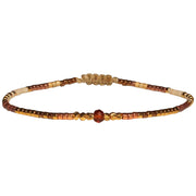   Handwoven in Colombia, this feminine bracelet features a single row of Japanese glass beads in gold and neutral tones with a Hessonite stone of clarity and confidence in the centre.  Wear this stylish bracelet alone or as a part of a bracelet layering combination, with your favourite jeans & t-shirt!  Details:  - Japanese glass beads  - gold vermeil faceted beads  - Hessonite  - Width: 2mm  - Adjustable bracelet 