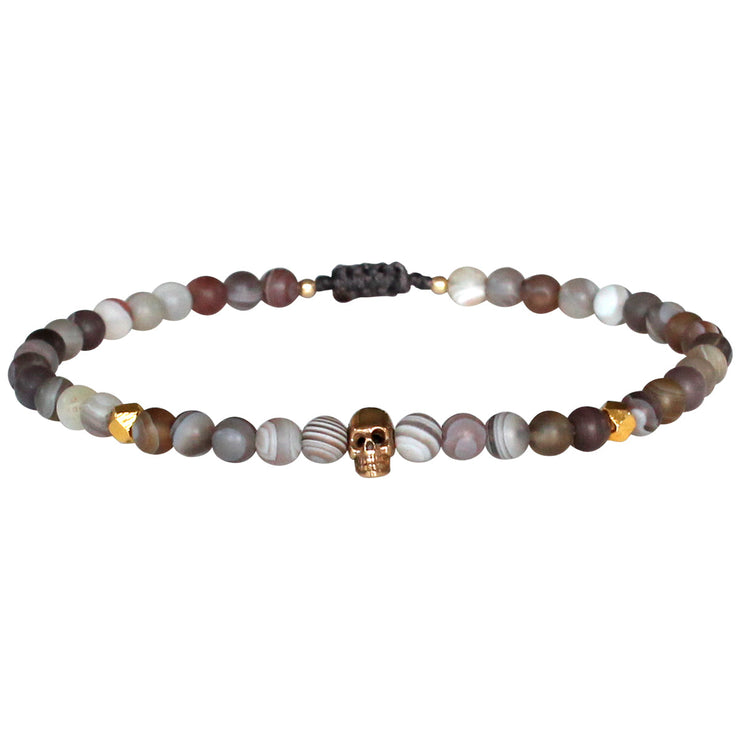 Expressive attitude meets artistic details.  This elaborately handcrafted piece of jewellery expresses strength and self-confidence.   Handmade using Botswana stone, 14k gold filled faceted beads and 14k gold filled   skull charm, this cool bracelet will give to your looks a touch of authenticity .  Details:  -Men bracelet  -Handmade bracelet  -Botswana stone   -14K gold filled skull detail  -14k gold filled faceted beads details   -Ajustable bracelet for men   -Width: 4mm