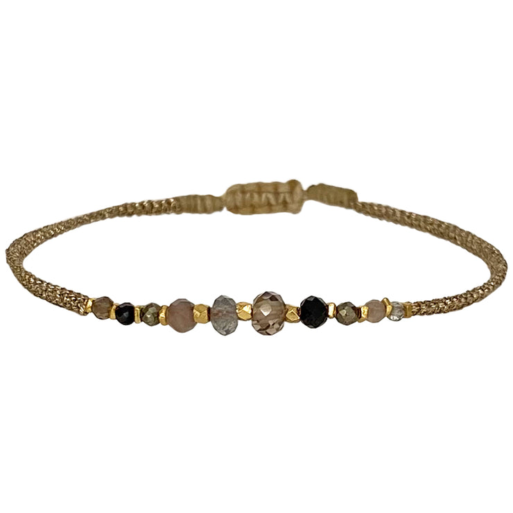 Delicate & feminine, our gypsy bracelet is handwoven using metallic gold threads and intermixed semi-precious stones.   Wear it with your favourite accessories all season long!  Details:  - Intermixed semi-precious stones   - vermeil faceted beads   -Metallic threads  -Adjustable bracelet   -Can be worn in the water  -It comes with a card and a gift box 
