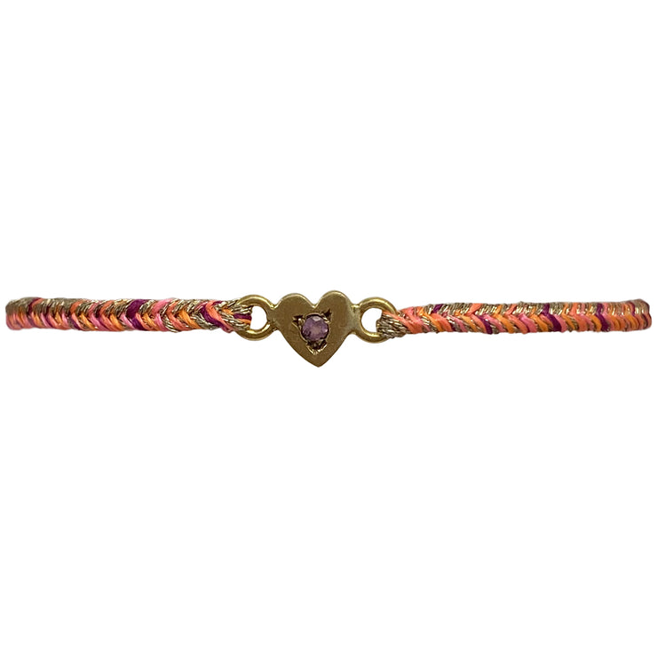 This delicate bracelet is handmade by our team of master artisans using metallic threads and a gold heart charm encrusted with a beautiful pink tourmaline stone. It&
