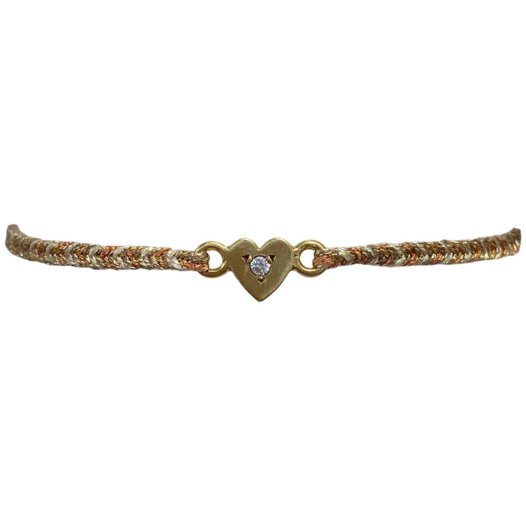 This delicate bracelet is handmade by our team of master artisans using metallic threads and a gold heart charm encrusted with a sparkling quartz stone. It&