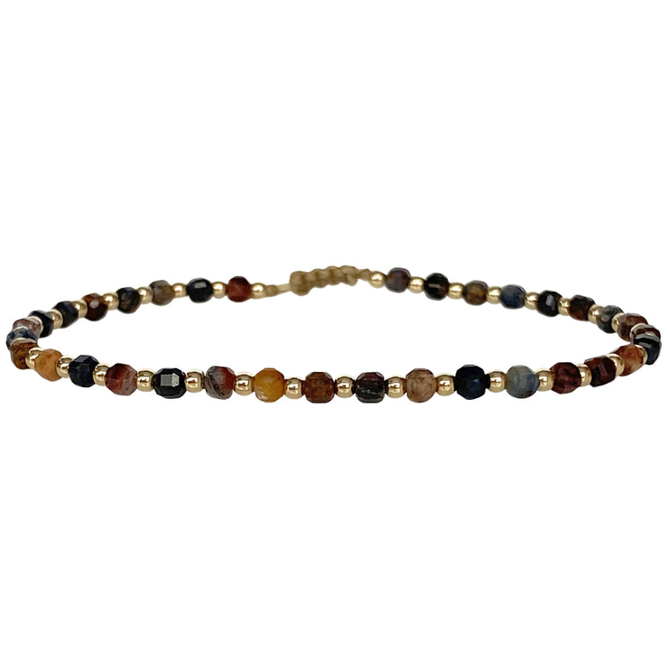 This delicate jewel is handmade using gold filled beads and Pietersite semi-precious stones. This beauty will be one of your favorite bracelets as you can wear it with any accessories or outfits. Give to your looks a touch of elegance and sparkle !  Details:  - Pietersite semi-precious stones   - 14 K gold filled beads  -Adjustable bracelet  -width: 2m  -Can be worn in the water