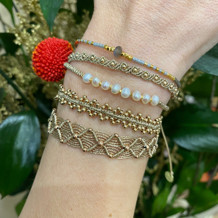 If you wish for simple elegance and versatility this handmade bracelet is just for you. It is handwoven by our team of artisans using 14 k gold beads and gold metallic threads.  Details:  - Women bracelet  - 14 K gold beads details   - Gold metallic threads  -Adjustable bracelet  -Width: 4mm