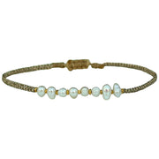 Delicate & feminine, this bracelet is handwoven using metallic gold threads and intermixed freshwater pearls and gold beads.  Wear it with your favourite accessories all season long!  Details:  - Metallic threads  - Adjustable handwoven bracelet   - Take care of your jewellery by keeping it dry and avoid spraying fragrances directly on to it.   - It comes with a card and a gift box 