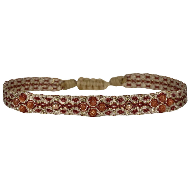 This beautiful handwoven bracelet features a mix of 14k rose gold filled beads and gold sandstone stones. The light gold and burgundy tones and delicate pattern in this bracelet can be worn all season.  This bracelet can be worn alone or stacked with your favourite pieces.  Details:      14k rose gold filled beads     Gold Sandstone     Handwoven adjustable bracelet     Width 6mm