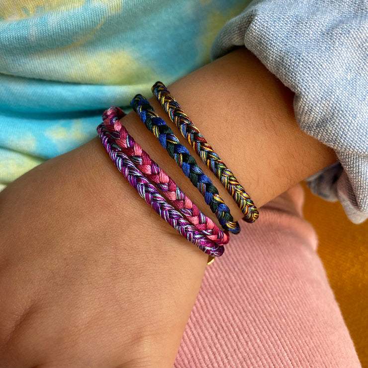 This bracelet is handwoven by our team of master artisans using polyester threads featuring a trenza design. This kids&